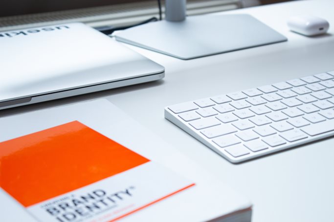 Apple products and a book titled orange Brand Identity